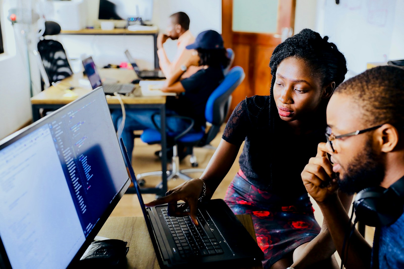 Two engineers reviewing code together on a laptop