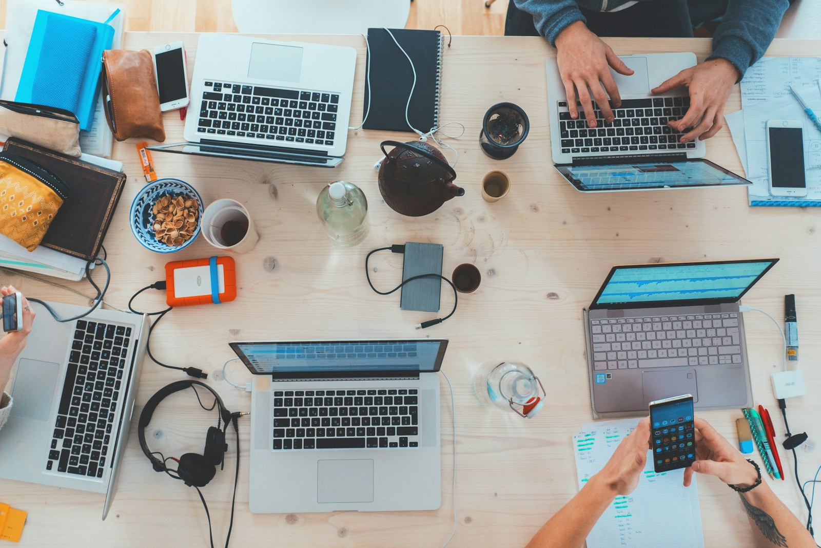 Team members working side by side on laptops around a shared desk